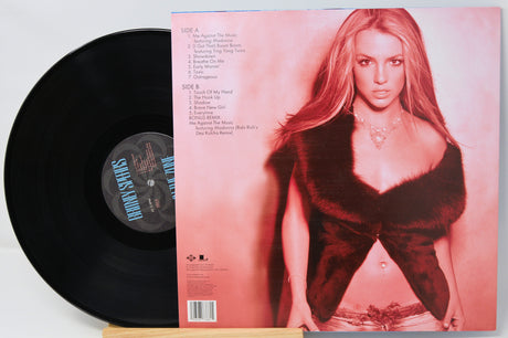 Vinyl record with a cover featuring a person in a red dress on a light pink background