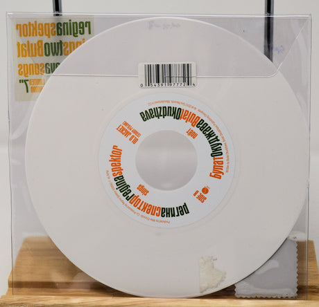 White vinyl record with a label on a wooden surface