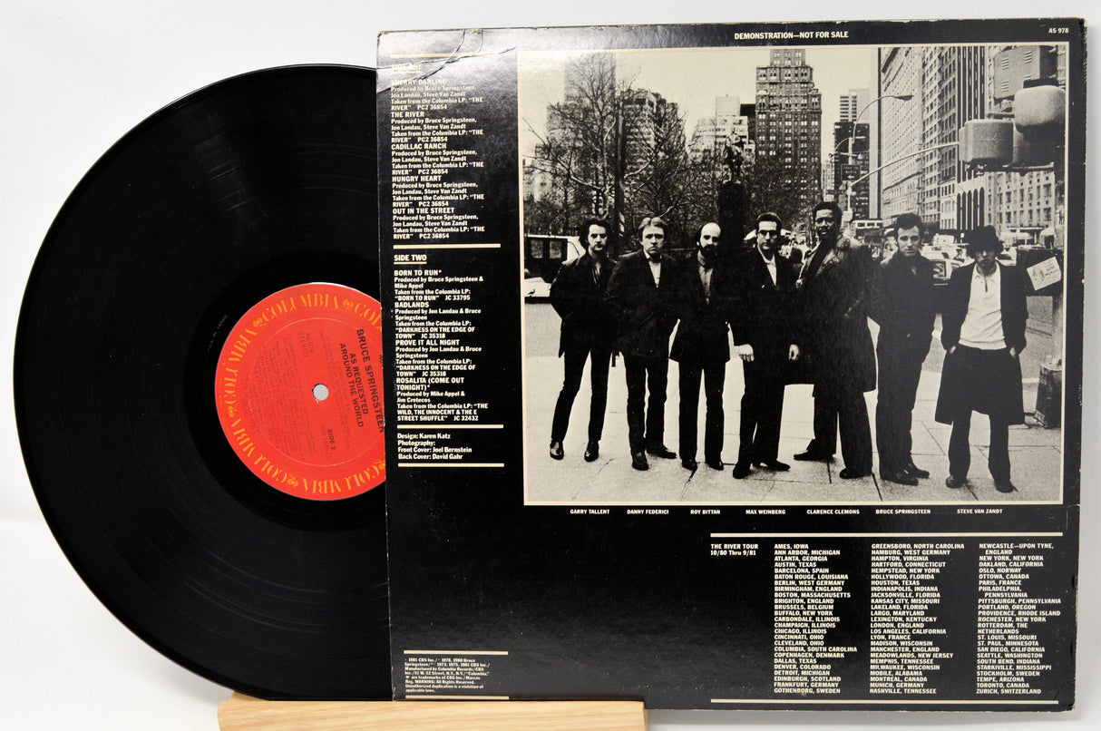 Vinyl record with cover featuring a black and white photo of a group of people in suits.