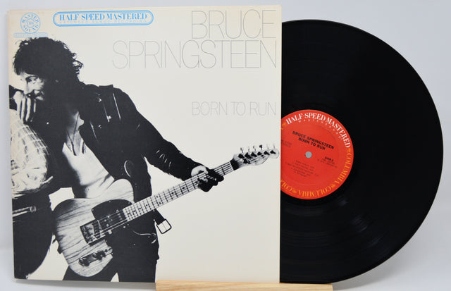 Vinyl record with cover featuring a musician playing guitar, on a light gray background