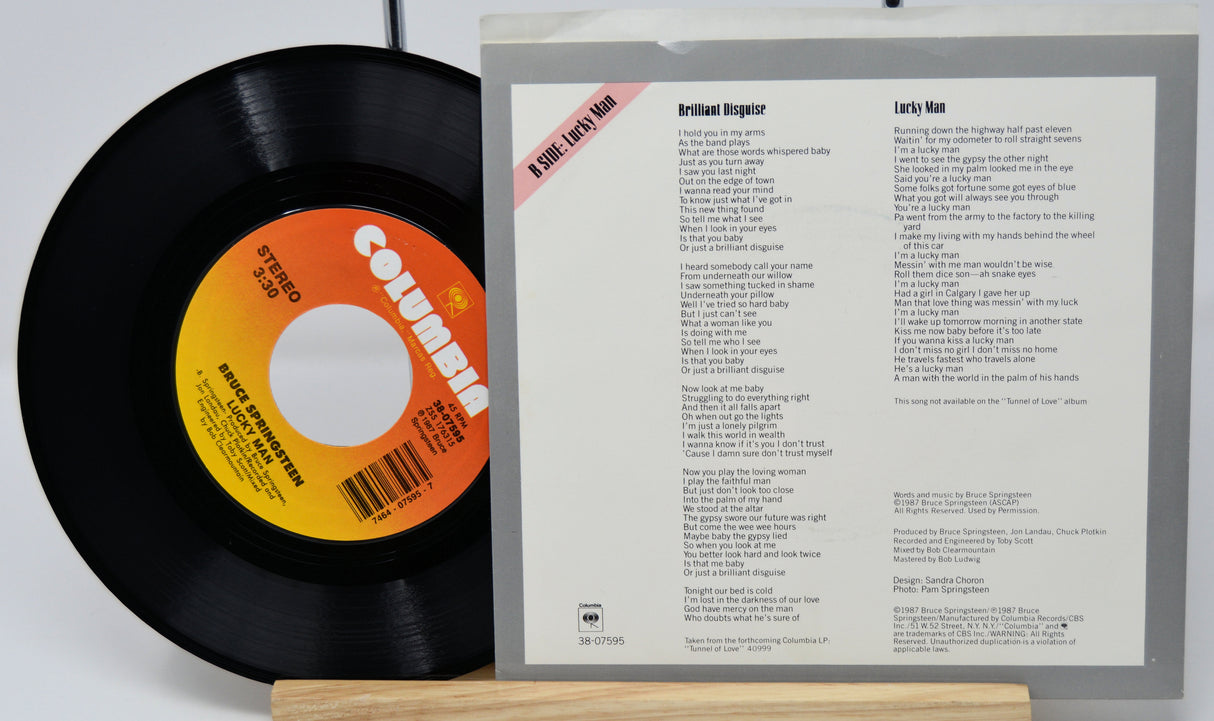 Vinyl record with Columbia label and record cover displaying tracklist on a white background