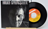 Vinyl record and cover featuring Bruce Springsteen on a white background