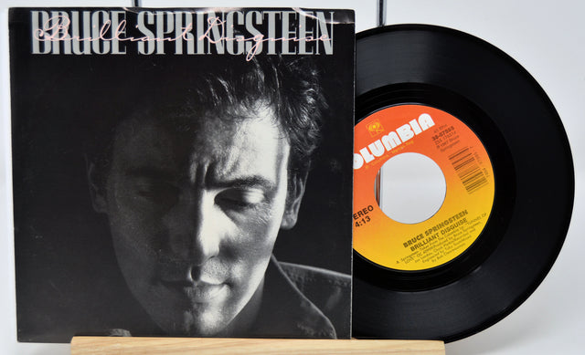 Vinyl record and cover featuring Bruce Springsteen on a white background