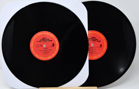 Two vinyl records with red labels on a white background