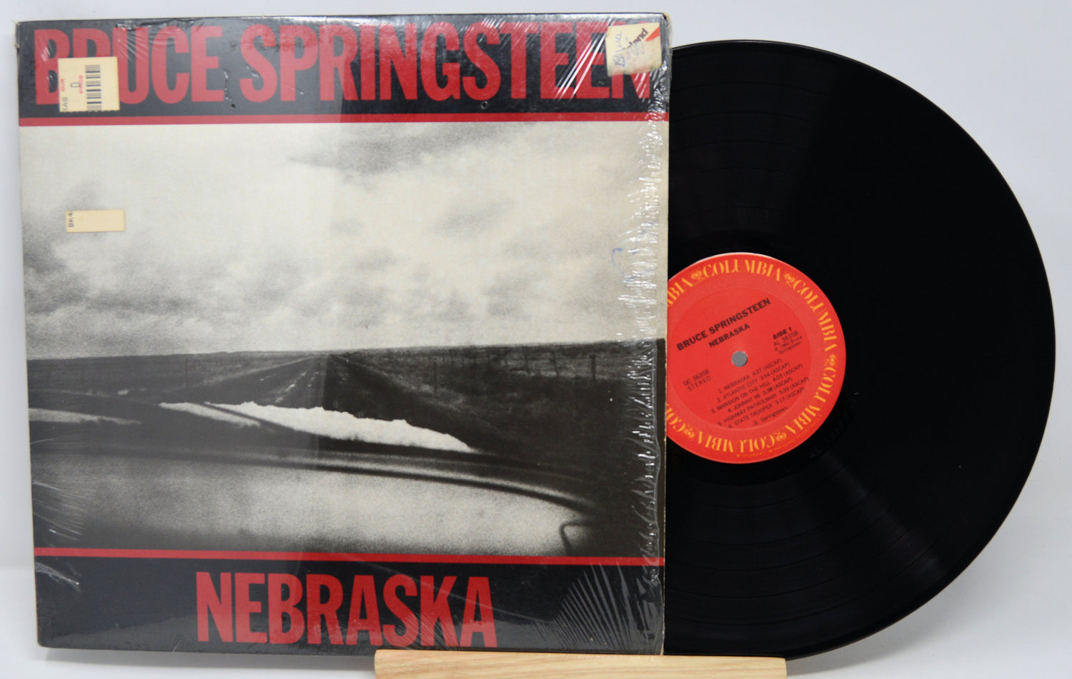 Vinyl record and cover of 'Nebraska' by Bruce Springsteen on a white background