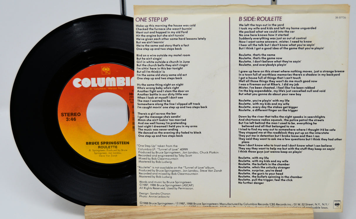Vinyl record with Columbia label and Bruce Springsteen song lyrics on a white background
