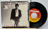 Vinyl record and cover of Bruce Springsteen's 'One Step Up' with Columbia label.