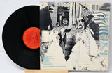 Vinyl record and back cover of Bruce Spingsteen album titled 'The River' showing paper cutouts of people in a wedding party.