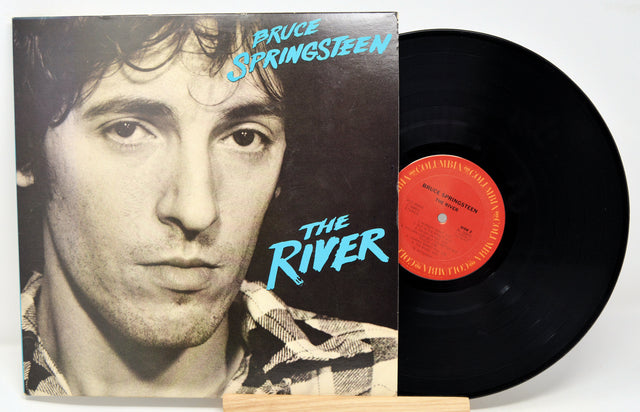 A used vinyl record of Bruce Springsteen's album 'The River' with the artist's photo on the cover, displayed alongside the black vinyl record.
