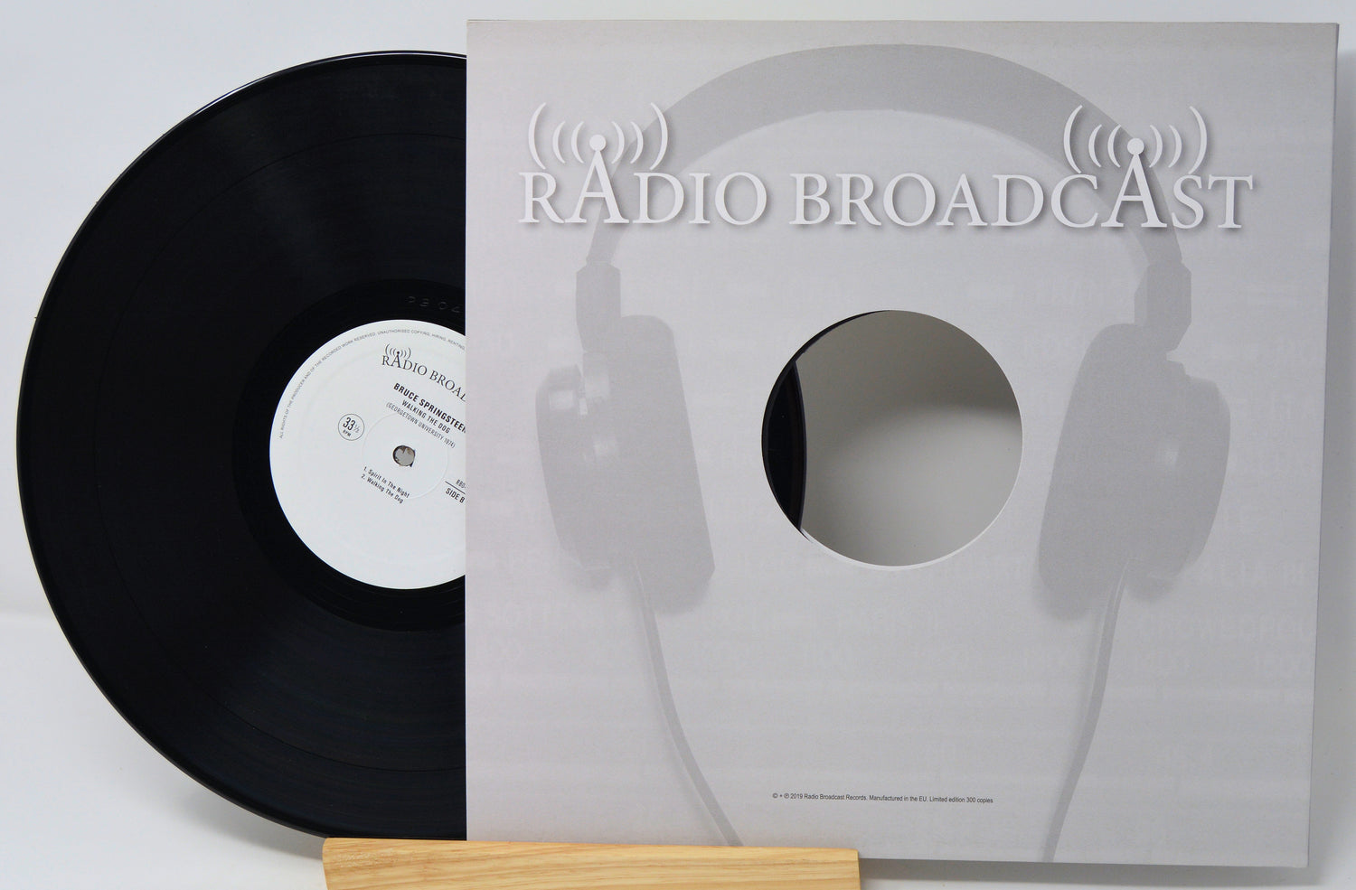 Vinyl record with a cover featuring headphones and 'Radio Broadcast' text on a white background