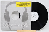 Vinyl record with cover featuring headphones and 'Radio Broadcast' text, displaying Bruce Springsteen's album 'Walking the Dog'.