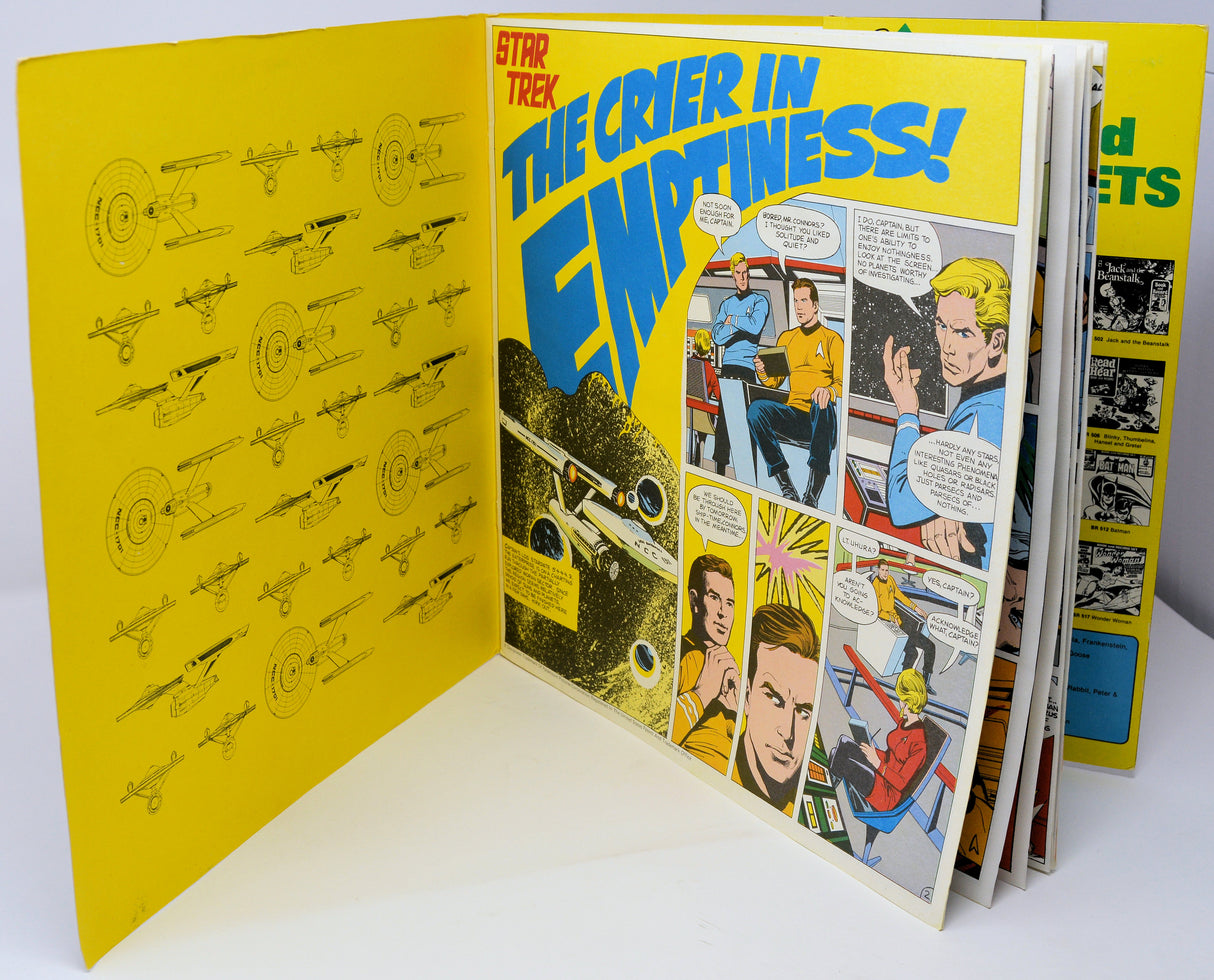 Comic book open to 'Star Trek' page with yellow cover and comic panels.