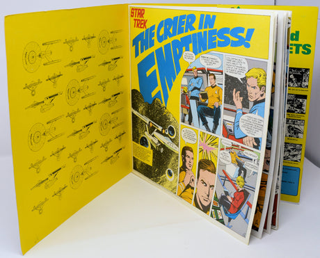 Comic book open to 'Star Trek' page with yellow cover and comic panels.