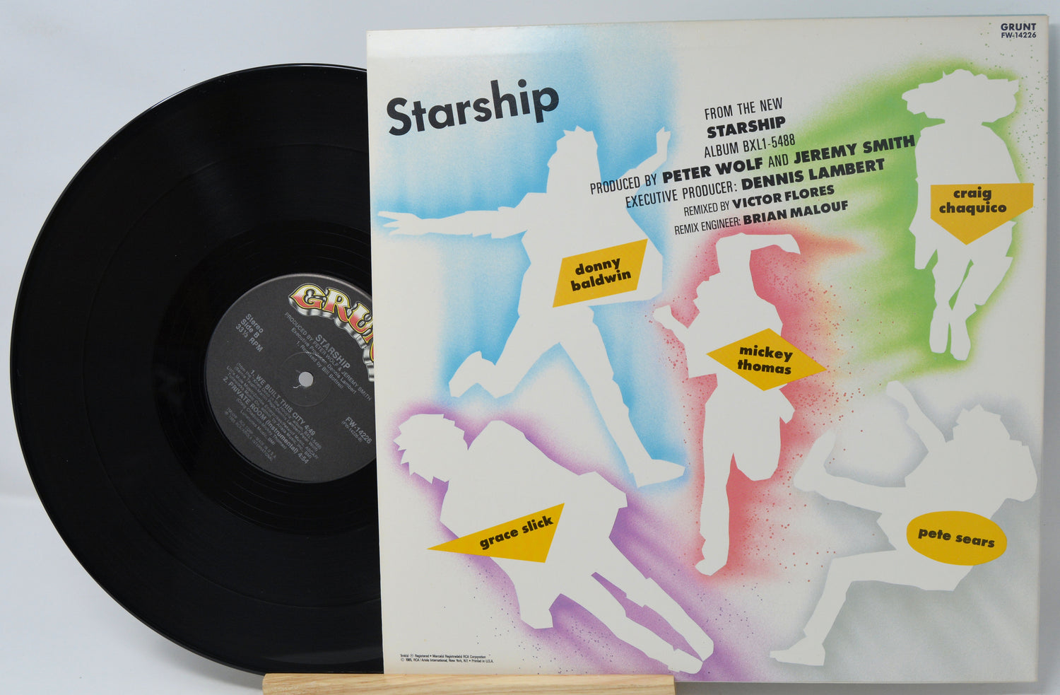 Vinyl record with colorful cover featuring silhouettes of people and text.