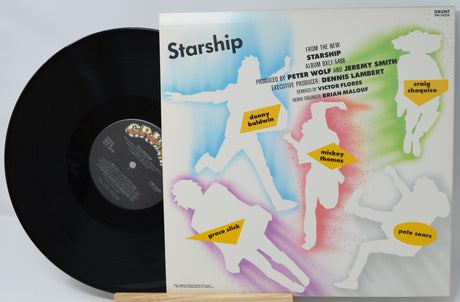 Vinyl record with colorful cover featuring silhouettes of people and text.