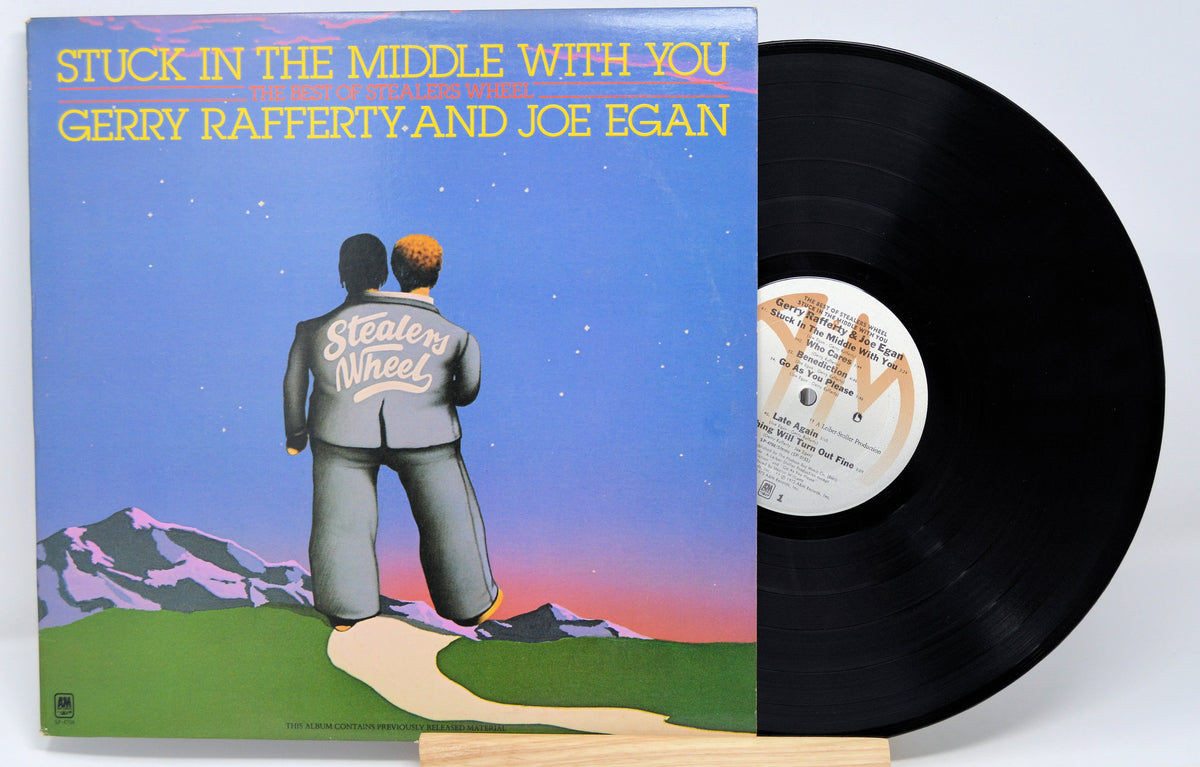 Vinyl record with cover featuring two people and mountain landscape, titled 'Stuck in the Middle with You'.