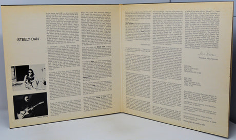 An open vintage magazine or booklet spread showing printed text columns and two small black-and-white photos on the left page, photographed against a plain light background.