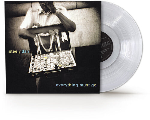 Vinyl record with cover featuring a person with a suitcase labeled 'steely dan everything must go' on a white background