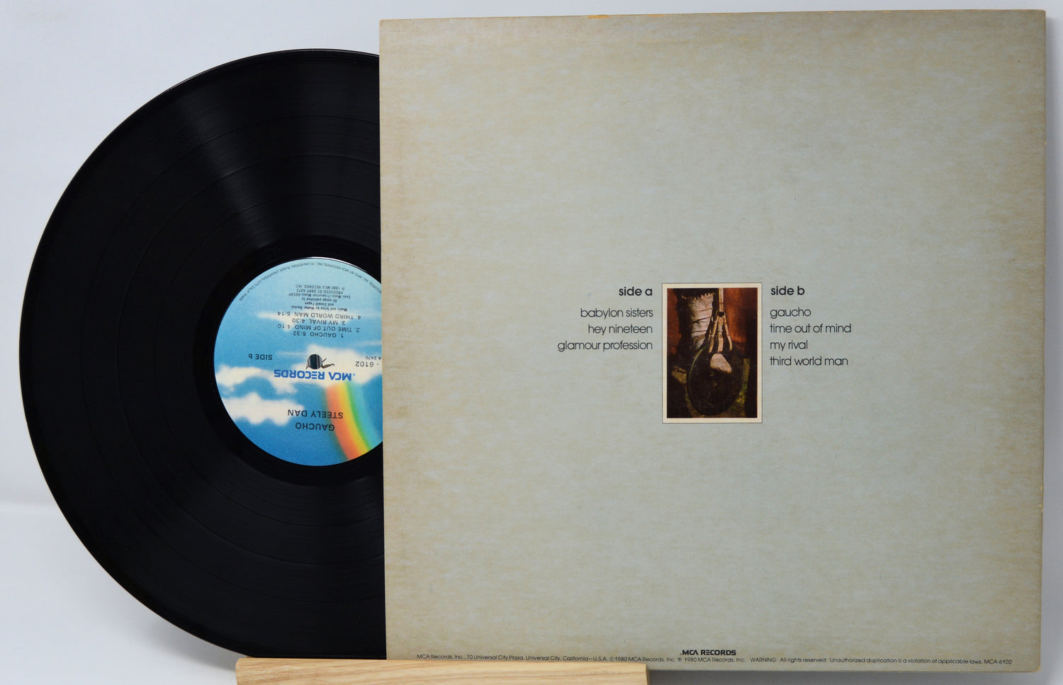 Vinyl record with a blue label featuring a rainbow and a photo of a man on the cover