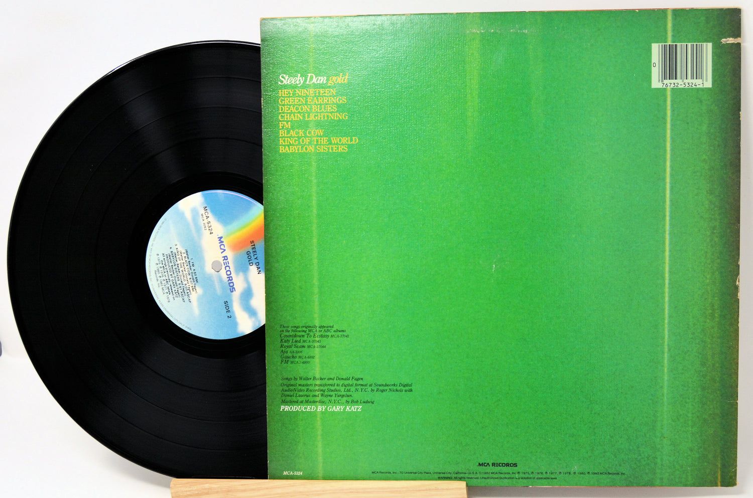 Vinyl record with green cover and blue label on a white background