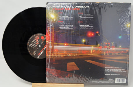 Back cover and vinyl record of Steely Dan's Northeast Corridor Live! album with tracklist and city street scene