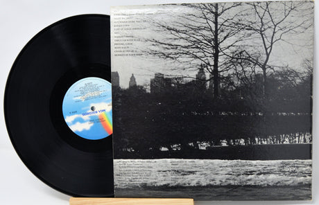 Vinyl record with a black and white cover featuring a tree and skyline.