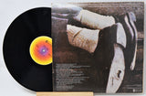 Vinyl record with cover featuring a person in a car, likely from a music album.
