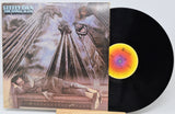 Vinyl record with cover featuring a stylized illustration of a man lying on a bed with a dragon above him.