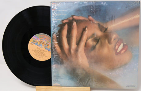 Vinyl record with a cover featuring a person's face and hands on a white background
