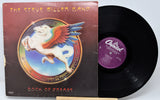 Vinyl record and cover of 'Book of Dreams' by The Steve Miller Band on a white background