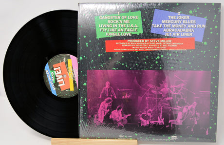 Vinyl record with cover featuring a band performance and colorful text on a white background