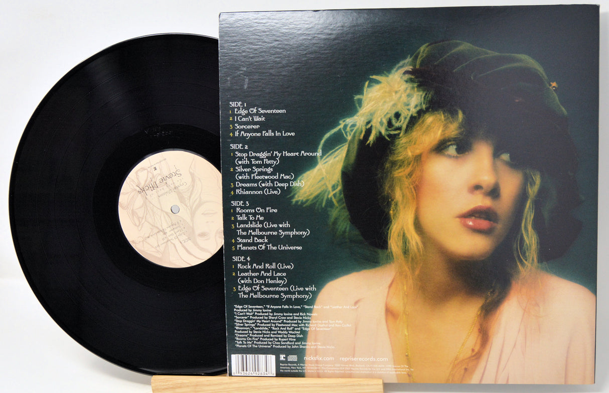 Vinyl record album shown with the black LP partially pulled from the sleeve, which features a printed track listing and a portrait of a woman with blonde hair and a dark hat.