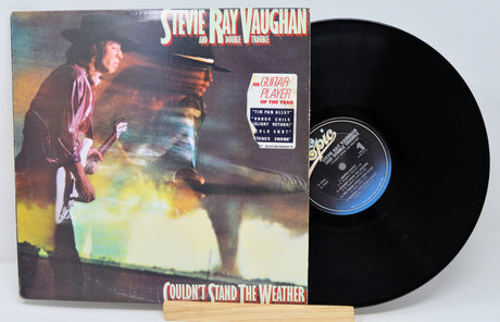 Vinyl record with front cover featuring a musician and album title 'Couldn't Stand the Weather' by Steve Ray Vaughan.