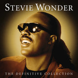 Stevie Wonder album cover for 'The Definitive Collection' featuring a photo of Stevie Wonder with sunglasses on, smiling, against a warm-toned background.