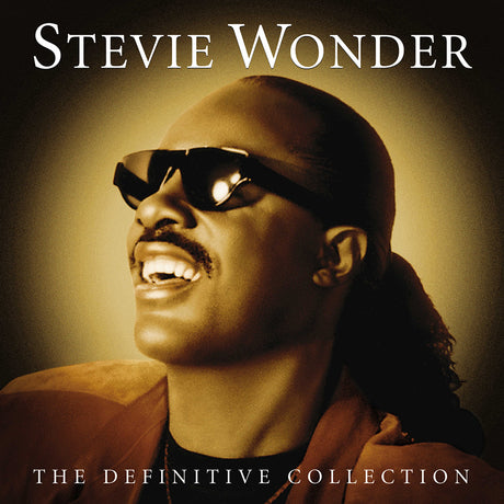 Stevie Wonder album cover for 'The Definitive Collection' featuring a photo of Stevie Wonder with sunglasses on, smiling, against a warm-toned background.