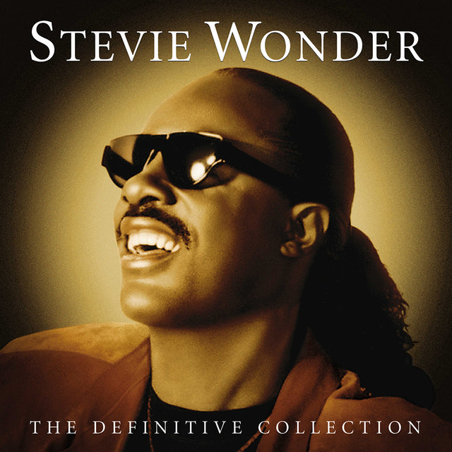 Stevie Wonder album cover for 'The Definitive Collection' featuring a photo of Stevie Wonder with sunglasses on, smiling, against a warm-toned background.