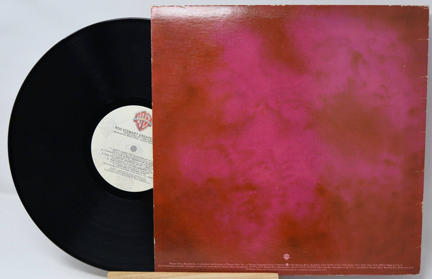 Vinyl record with a red and black cover on a light gray background