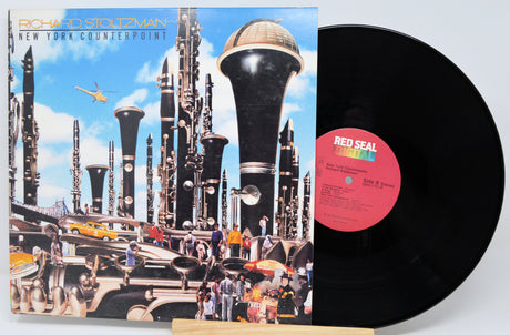 Vinyl record with a futuristic album cover featuring tall buildings and a helicopter.