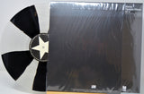 'Stone Temple Pilots' vinyl record with a black and white star design on the label, next to its packaging.