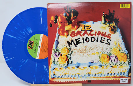 Vinyl record with blue disc and colorful cover featuring a cake and text.