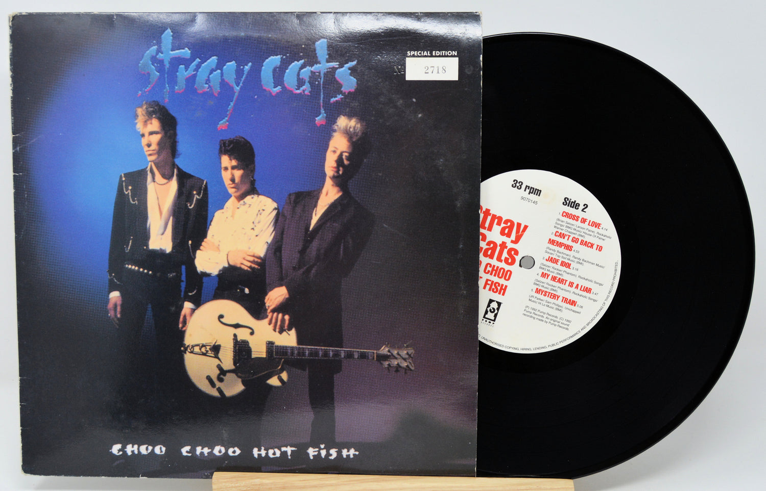 Vinyl record with 'Stray Cats' album cover featuring three band members and a guitar.