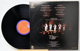 Vinyl record with cover featuring a band on stage