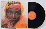 Vinyl record with a cover featuring a black and white photo of a person sitting outdoors.