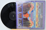 Vinyl record with a colorful cover featuring the word 'Paradise' on a white background