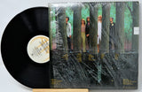 Vinyl record with a cover featuring people in a forest setting
