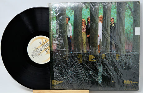 Vinyl record with a cover featuring people in a forest setting