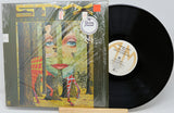 Vinyl record with a colorful cover featuring a face and trees, on a white background.