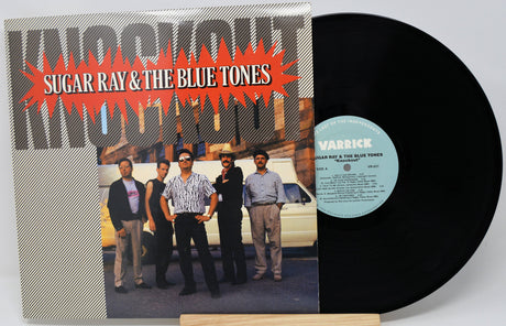 Vinyl record with cover featuring a group of people and text 'Sugar Ray & The Blue Zones, Knockout' on a white background.