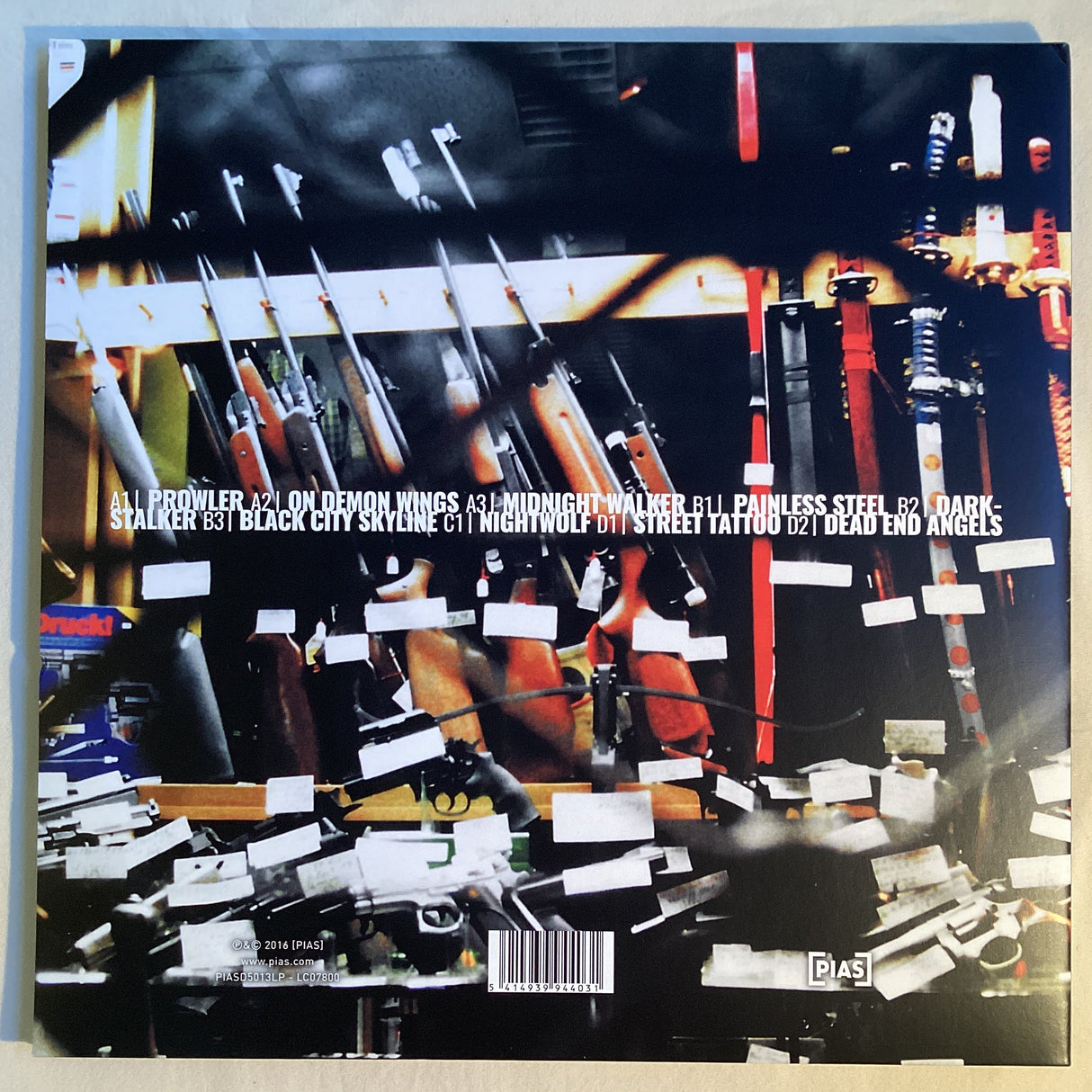 Back cover of Sunset Mission LP showing tracklist and blurred firearms art