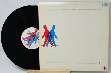 Vinyl record with a colorful cover featuring abstract human figures on a light gray background.